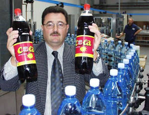 Ralph Weitemeyer steht in der Fabrik und hält 2 Flaschen Asco Cola in den Händen